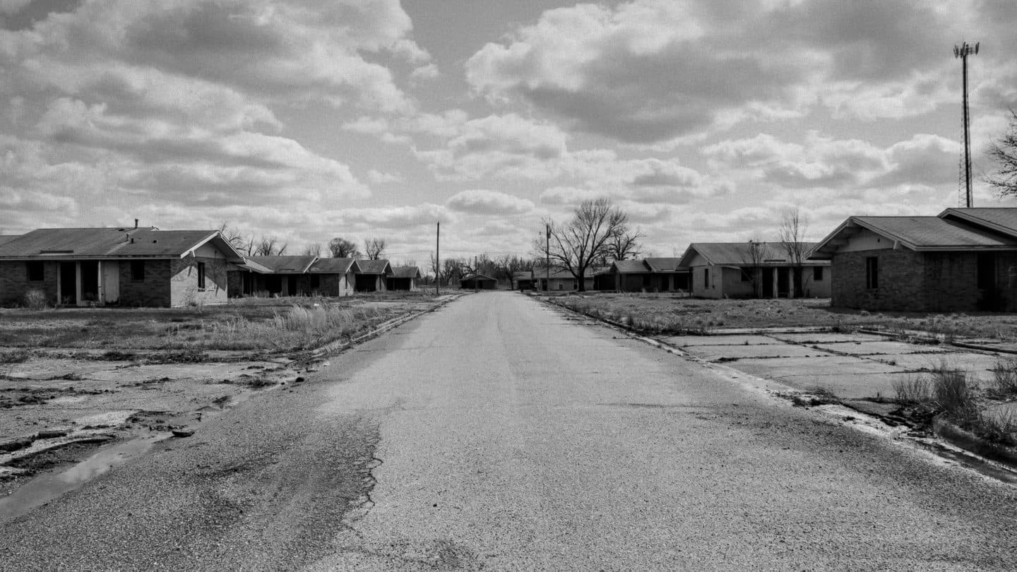 Vacant abandoned houses along a cracked empty street after the town was left behind