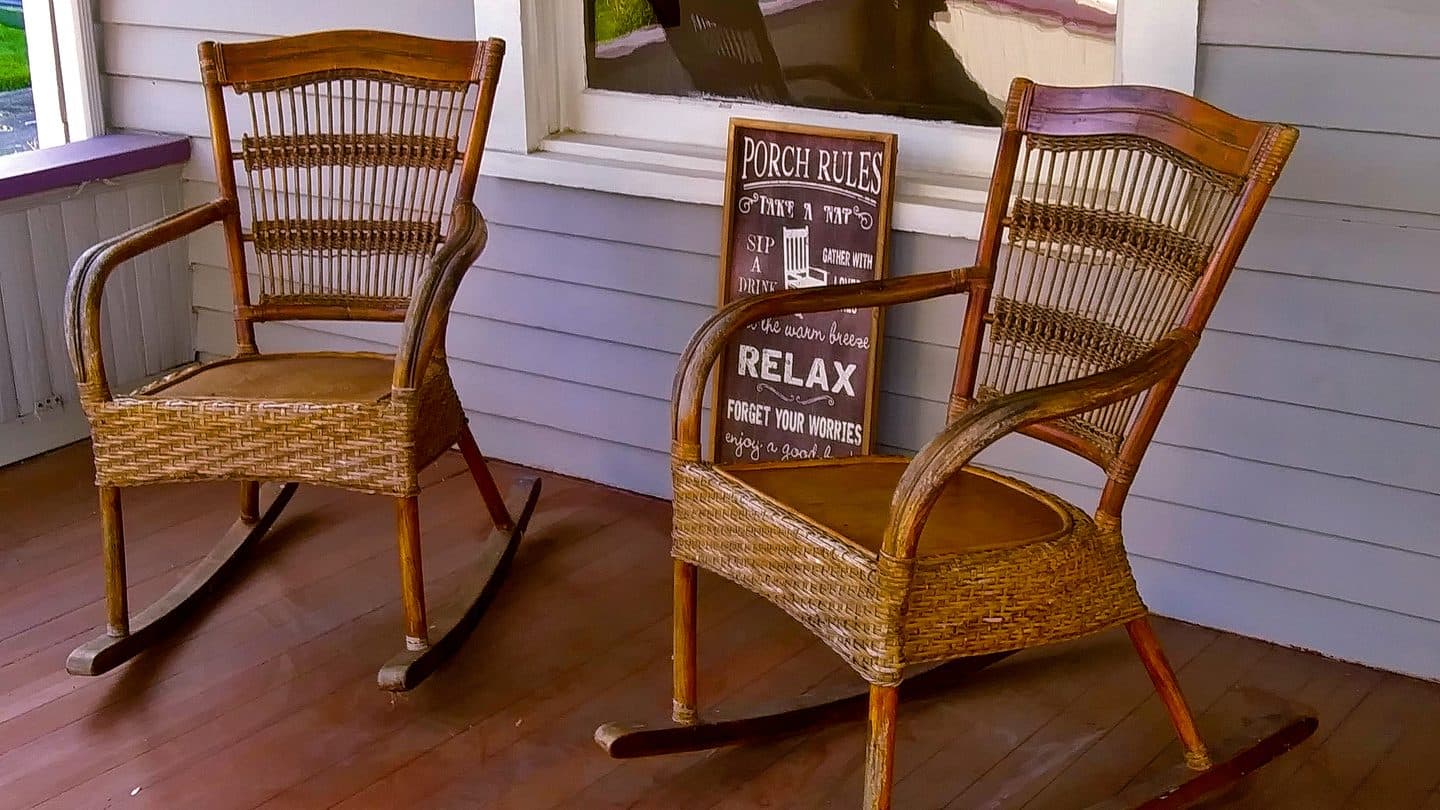 Occupied front porch with two rocking chairs on a modest house